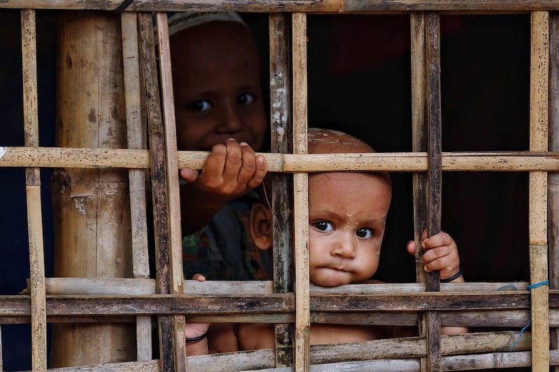 Rohingya refugee children look on from their shelter at a refugee camp in Cox's Bazar, Bangladesh, Sept. 28, 2024.