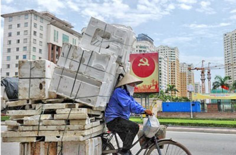 Một công nhân tranh thủ thu gom những vật dụng phế thải. AFP