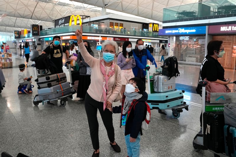 Passengers wearing face masks line up at the check-in counter for Singapore in Hong Kong International Airport, April 1, 2022. Credit: Associated Press. Credit: AP