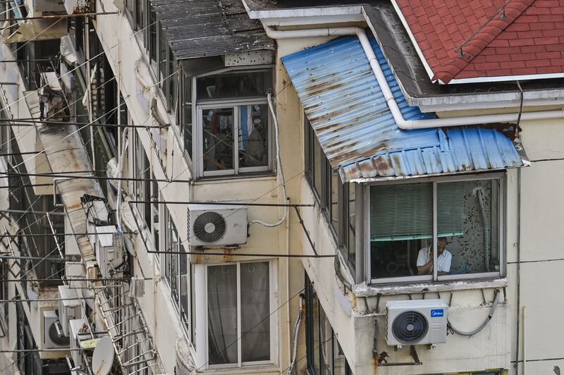 A man looks outside from his window during a COVID-19 lockdown in Shanghai's Jing'an district, April 12, 2022. Credit: AFP