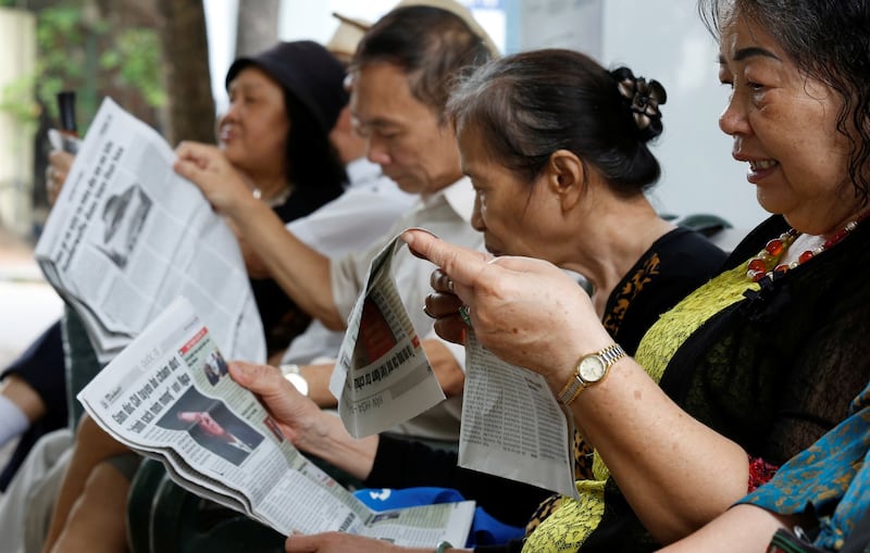 People read newspapers by the Hoan Kiem lake in Hanoi, Vietnam May 3, 2018. Credit: Reuters