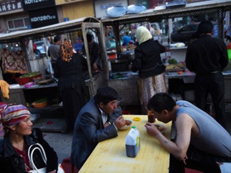 Uyghurs eat at a food stall in a night market in Hotan, April 15, 2015. 