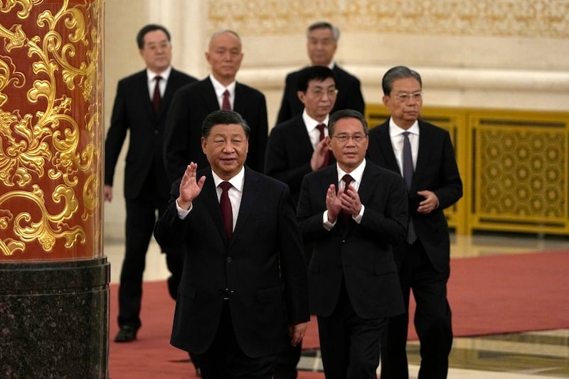 New members of the Politburo Standing Committee, front to back, President Xi Jinping, Li Qiang, Zhao Leji, Wang Huning, Cai Qi, Ding Xuexiang, and Li Xi arrive at the Great Hall of the People in Beijing, Sunday, Oct. 23, 2022. Political commentator Cai Shenkun believes Xi worries that one of the Politburo members could one day take him down. Credit: Associated Press