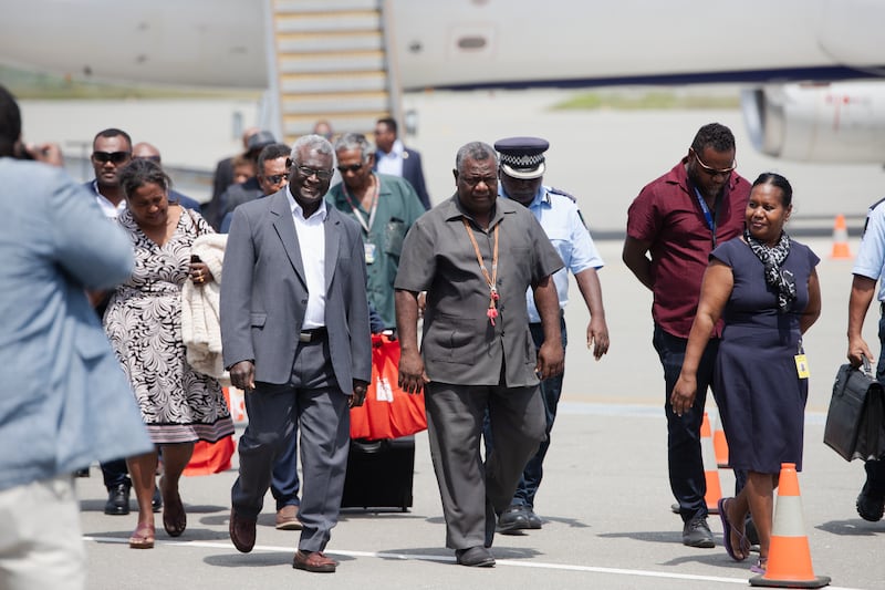 Solomon Islands Prime Minister Manasseh Sogavare (center left) walks across the tarmac at Honiara International Airport on Sept. 27, 2023 after returning from New York where he spoke at the United Nations General Assembly. Credit: Charley Piringi/BenarNews