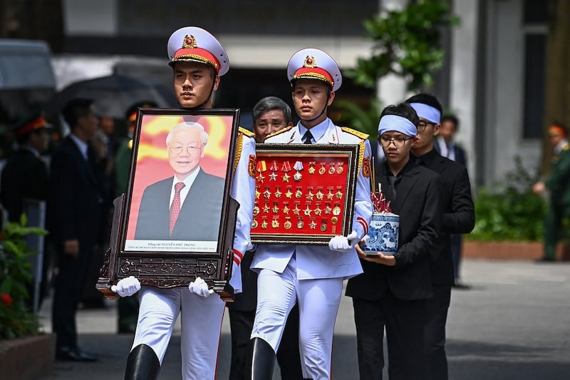 A member of Vietnam's armed forces carries a portrait of the late General Secretary of the Communist Party Nguyen Phu Trong during his funeral in Hanoi on July 26, 2024. (Nhac Ngueyn/Pool via AFP)