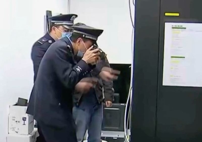 Chinese police take photographs during a raid on the office of Capvision, a consultancy firm, in Shanghai in 2023. (Image from CCTV via AP)