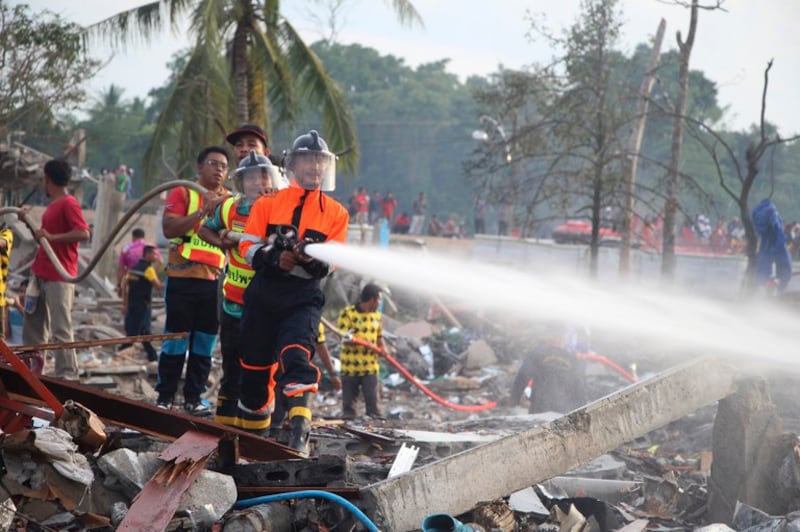 A firefighter sprays water following a deadly explosion at a warehouse where fireworks were kept in Narathiwat province southern Thailand, July 29, 2023. Credit: Kriya Tehtani/AP