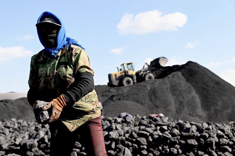 A worker sorts coal near a coal mine in Datong, China's northern Shanxi province, Nov. 3, 2021. Credit: AFP