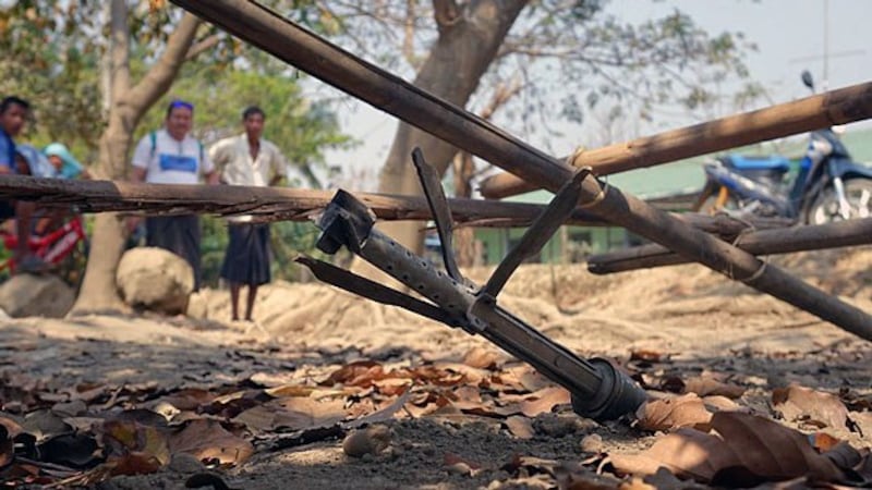 Villagers look at an unexploded rocket from fighting between the Myanmar military and Arakan Army in Mrauk-U township, western Myanmar's Rakhine state, March 16, 2019.