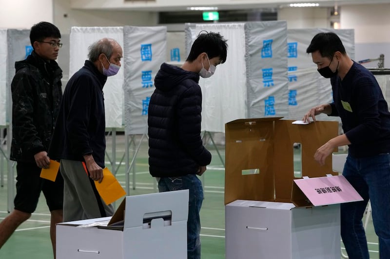 台湾采用纸制票匦，投票前选务人员会让民众确认票箱为净空状态。 （图／美联社）