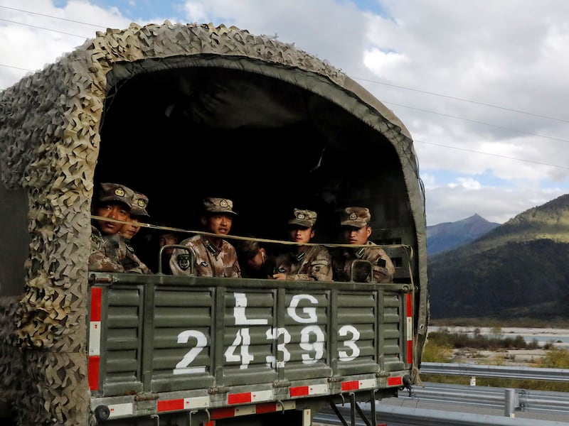 Chinese soldiers of the People's Liberation Army sit on the back of a truck on the highway to Nyingchi, Tibet Autonomous Region, China, October 19, 2020)