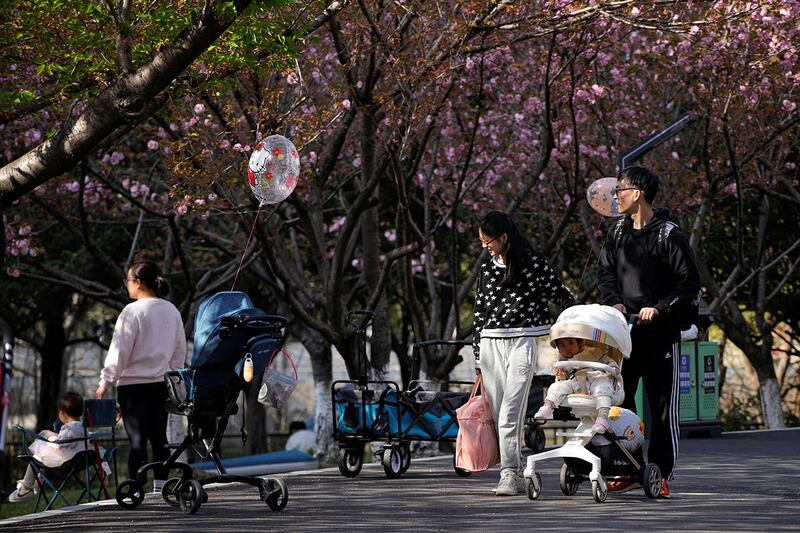 2023年4月2日，在上海公园里，一对父母推着婴儿车。（路透社）