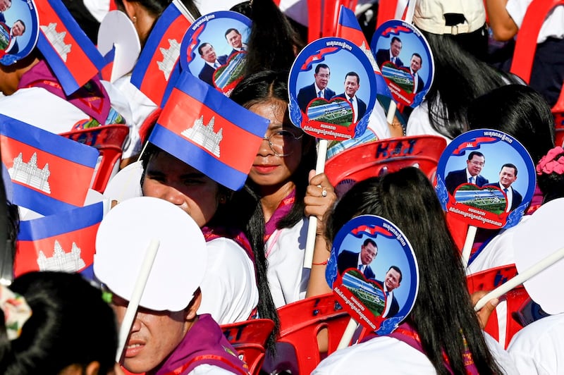 People carry small Cambodia national flags and banners during the groundbreaking ceremony of the Funan Techo Canal in Kandal province, Aug. 5, 2024. (Tang Chhin Sothy/AFP)