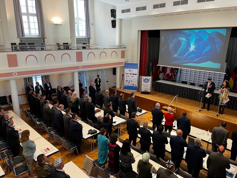 Summit attendees listen to a recording of the national anthem of East Turkestan, the name Uyghurs use to refer to their homeland in northwestern China, at a conference hall in Munich, Germany, May 26, 2022. Credit: RFA