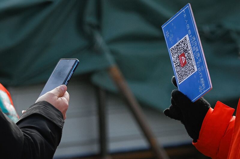 A man uses his smart phone to register with China's COVID-19 Health Code app, in a file photo. Credit: AFP