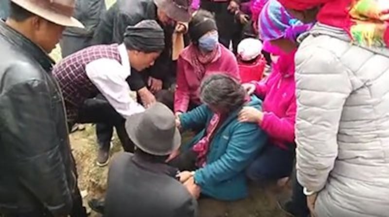 Villagers attend to a Tibetan woman injured during a clash with police in Qinghai's Bayen (Hualong) Hui Autonomous county, June 1, 2017. Credit: RFA listener