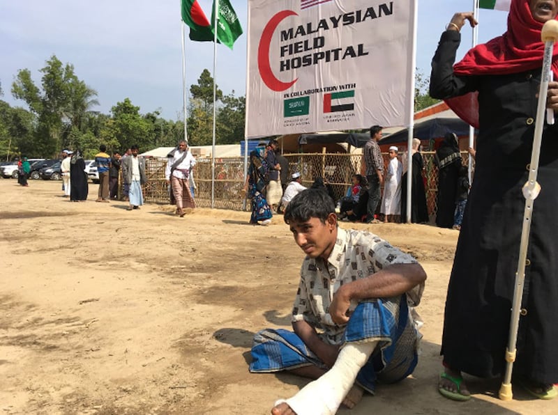 An injured Rohingya boy sits outside the Malaysian Field Hospital in Cox's Bazar after being treated there, Jan. 27, 2018.