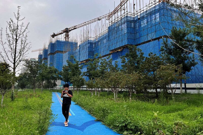 A man walks past a construction site of residential buildings by Chinese developer Country Garden, in Beijing, Aug. 11, 2023. Concerns over China's real-estate sector have grown to anxiety over the country's overall economic health and the viability of its investment-led development model. Nowhere have those concerns reverberated more than in Southeast Asia. Credit: Tingshu Wang/Reuters