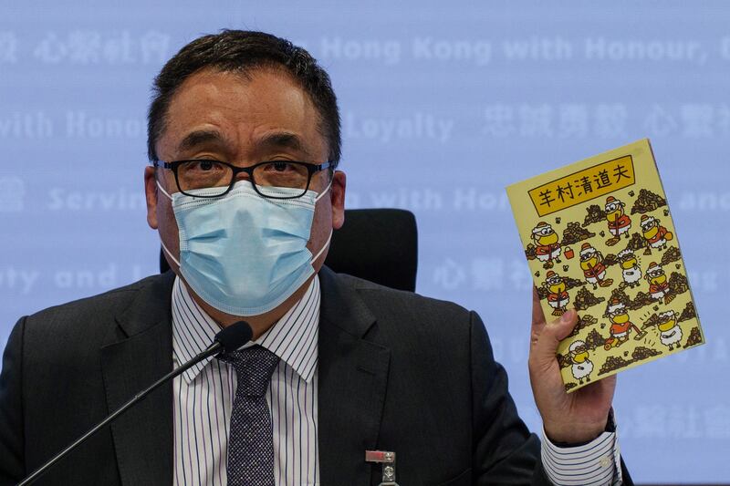 Hong Kong's senior superintendent Steve Li, from the city's new national security police unit, holds up a children's book which allegedly tries to explain about the city's democracy movement, at a police press conference in Hong Kong, July 22, 2021. Credit: AFP