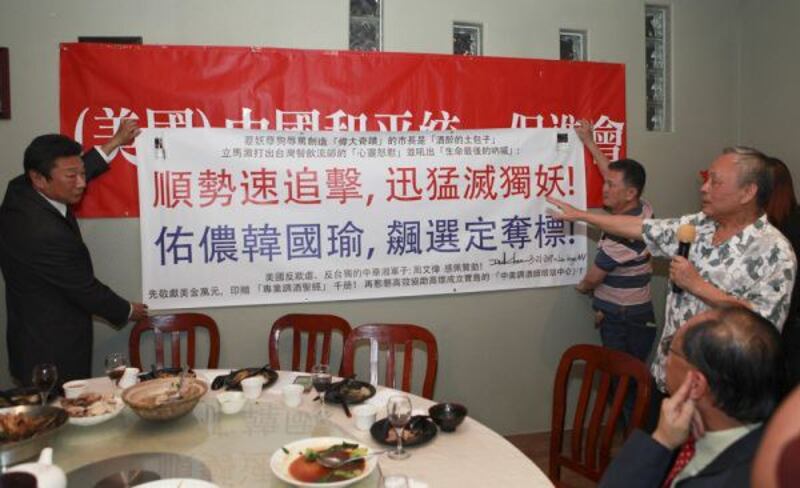 David Chou holds up a banner calling for the 'eradication of pro-independence demons,' at the Las Vegas Association for China's Peaceful Unification, April 2, 2019. Credit: LVNews