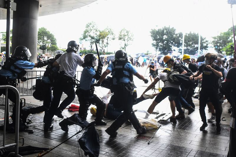 2019年6月12日，香港市民反《逃犯条例》示威活动中，多名防暴警察挥舞警棍殴打一名示威男子。（法新社）