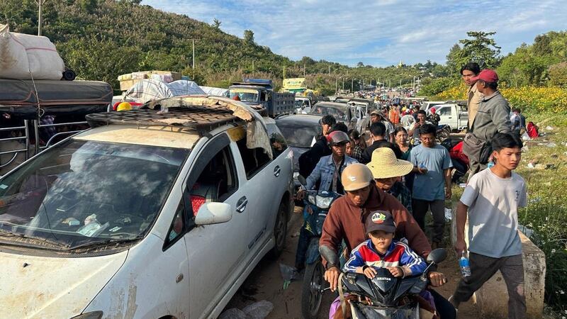 Displaced persons returning to Laukkai, Myanmar, are seen near the entrance to Lashio on Nov. 30, 2023 (RFA)