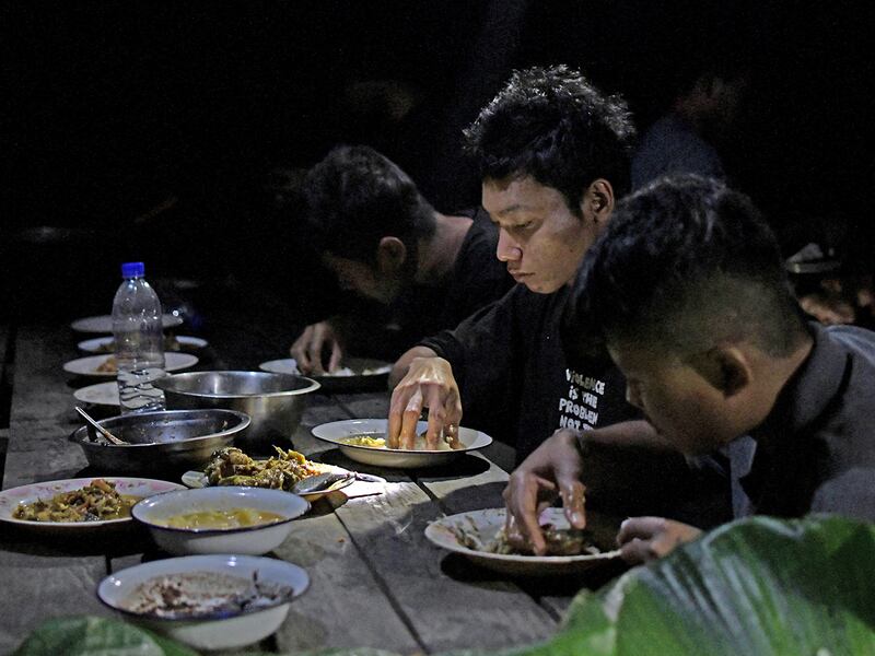 Members of Bamar People's Liberation Army eat  dinner in territory belonging to the Karen National Liberation Army in Karen State, Myanmar, February 17, 2024.