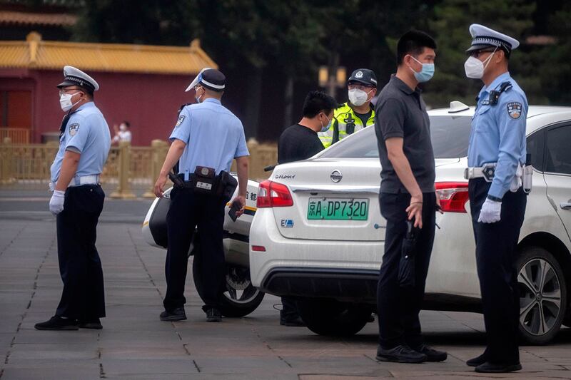 警察在北京天安门广场附近的一条街道上与一名男子交谈。（美联社）