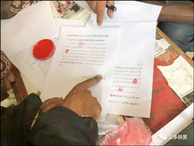 A Tibetan villager makes a fingerprint on an official document, agreeing to be relocated to Sinpori, a mass resettlement site 60 kilometers (37 miles) southwest of Lhasa, capital of western China's Tibet Autonomous Region, in an undated photo. (Poverty Alleviation Office, Anduo County, Nagqu, TAR via HRW)