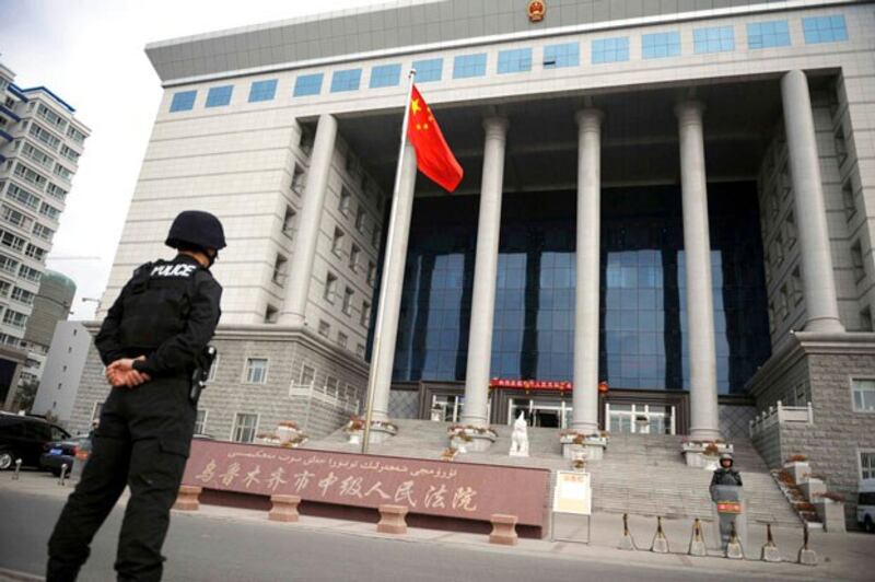 Police officers stand guard outside the Intermediate People's Court in Urumqi in northwest China's Xinjiang Uyghur Autonomous Region, Oct. 12, 2009. (Wang Fei/Xinhua via AP)