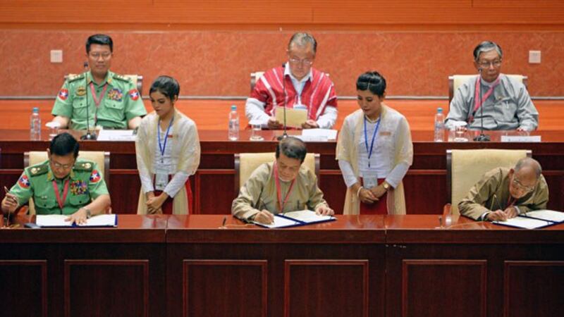 Myanmar military officials, government peace negotiators, and representative of ethnic armed groups sign a document during the closing ceremony of the third session of the Union Peace Conference in Naypyidaw, July 16, 2018.