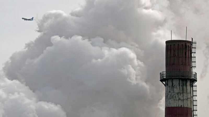 A passenger airliner flies past steam and white smoke emitted by China Huaneng Group's coal-fired power plant in Beijing, Feb. 28, 2017. The power plant was closed in March 2017 as part of the the Chinese capital's conversion to clean energy. 