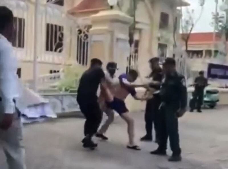 Keo Sovannrith is manhandled by police outside the Ministry of Education, Youth and Sports in Phnom Penh, Cambodia, in a screenshot from a video posted to Facebook Aug. 21, 2023. Credit: Screenshot from Facebook