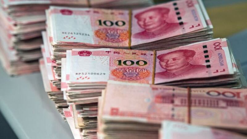 Bundles of 100-yuan notes sit on a desk at a bank in Shanghai, China, Aug. 8, 2018.