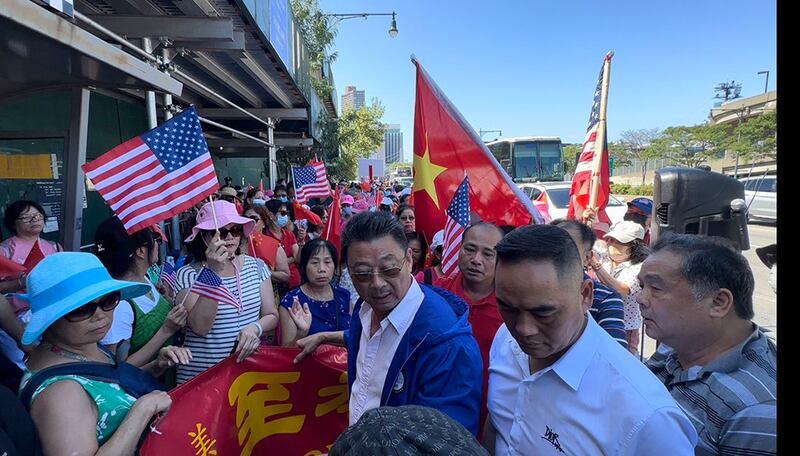 演讲场外有上百名来自大陆亲共侨团的抗议人士出现。他们手持五星旗，用大喇叭高声播放中共红色宣传歌曲，并高喊“一个中国，消灭台独”等口号。(记者凯迪拍摄)