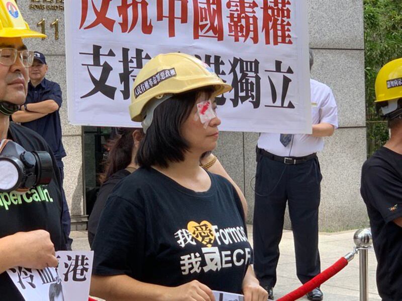 台联组织部主任周倪安以戴眼罩方式抗议港警施暴。(记者 黄春梅摄)