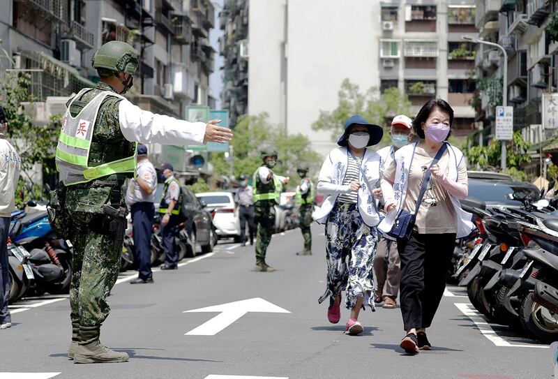 2022年7月25日，士兵在台湾台北举行的万安空袭演习中将人们引导到地下避难所。（美联社）