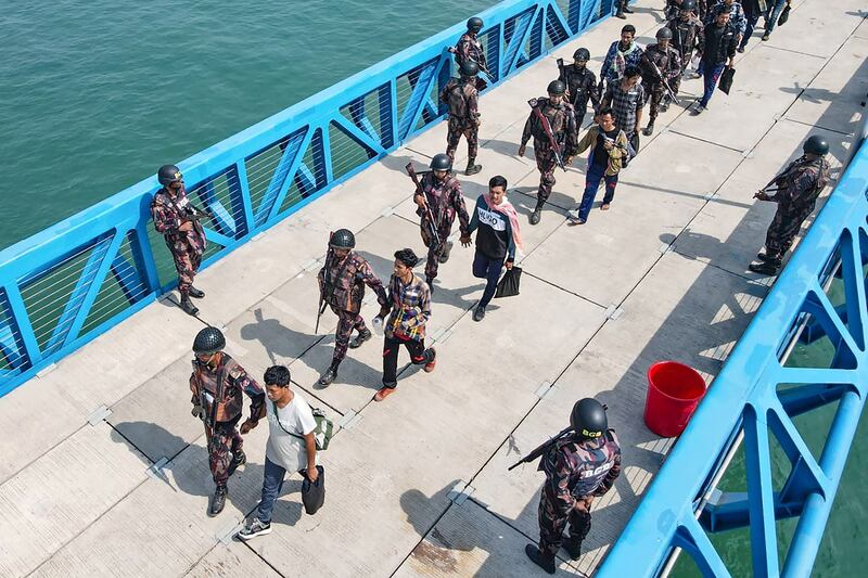 Bangladesh authorities escort Myanmar nationals and Border Guard Police personnel, who fled into Bangladesh to seek shelter, back to their country by boat at Cox's Bazar on Feb. 15, 2024. (AFP)