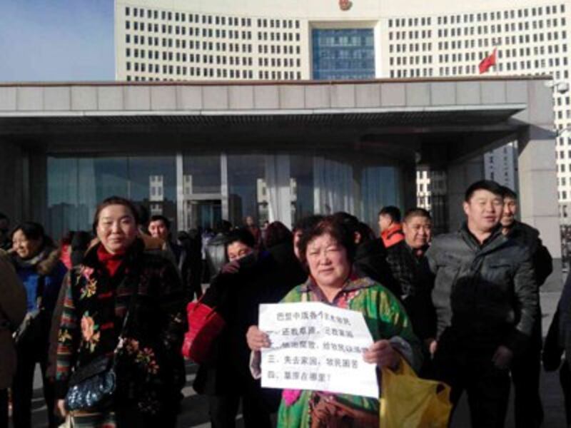 A protestor holds a sign outside a government building in Hohhot, Inner Mongolia, Jan. 26, 2015.