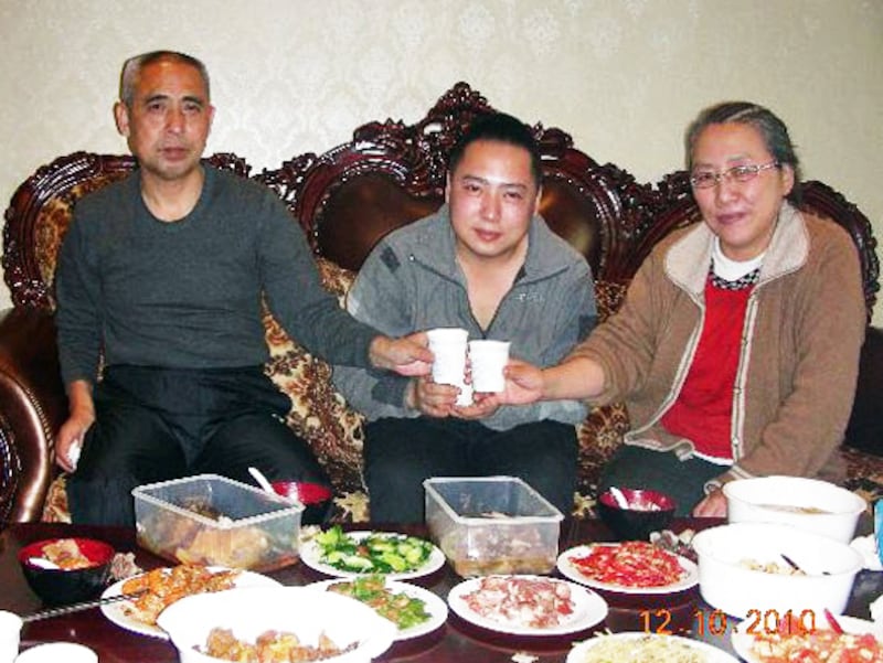 Mongolian dissident Hada, left, shares a meal with son Uiles, center, and wife Xinna in undated photo.