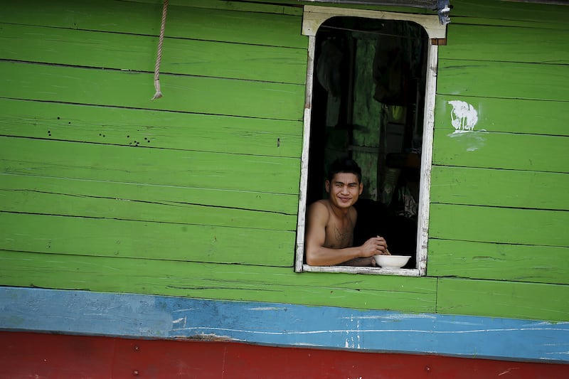 A man sits on a boat on the Mekong river at the border between China, Laos and Myanmar March 1, 2016.