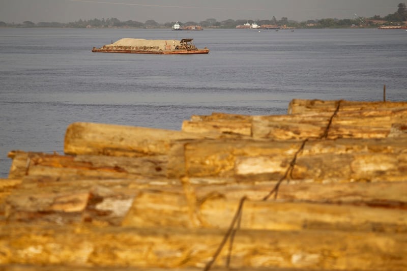 A vessel travels near teak logs awaiting export in the Bago river in Yangon, Feb. 2, 2014. Picture taken Feb. 2, 2014. Credit: Reuters