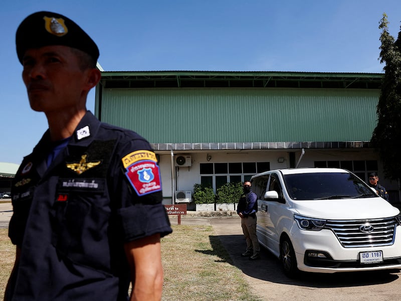 A  police officer stands watch as the vehicle carrying Ekkalak Paenoi, a suspect in the assassination of a former politician Lim Kimya, is taken to police in Bangkok, Thailand, Jan. 11, 2025.