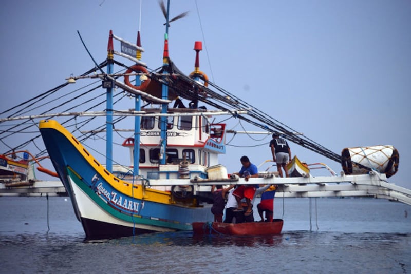 Filipino fishermen board their boat anchored along the Infanta fish port in Pangasinan, north of Manila, May 27, 2021. Credit: BenarNews