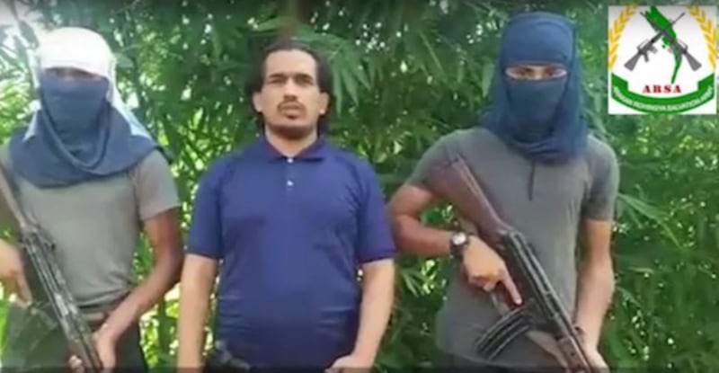 A man identifying himself as Ataullah Abu Jununi (center), commander of the Arakan Rohingya Salvation Army, delivers a statement to the Myanmar government and ethnic groups in Rakhine state in this image from a social media video, Aug. 28, 2017.