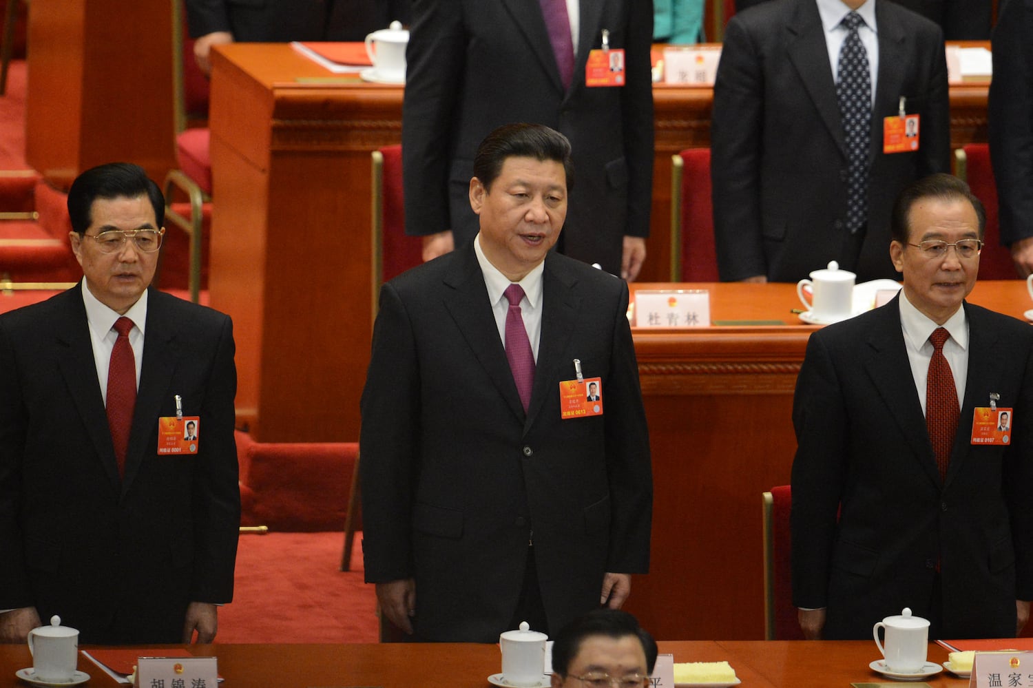 (L-R) Former Chinese President Hu Jintao, newly elected Chinese President Xi Jinping and former Premier Wen Jiabao sing the national anthem at the closing session of the National People's Congress in Beijing on March 17, 2013.