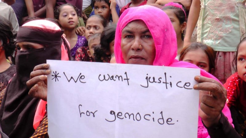 A Rohingya woman's handwritten sign calls for justice as she participates in a rally at a Cox's Bazar refugee camp in Bangladesh, Aug. 25, 2022. Credit: BenarNews