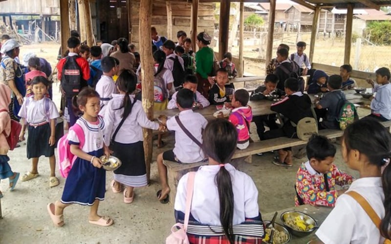 Students eat lunch provided by international donors at a rural school in Savannakhet province, Laos, March 2023. (RFA)