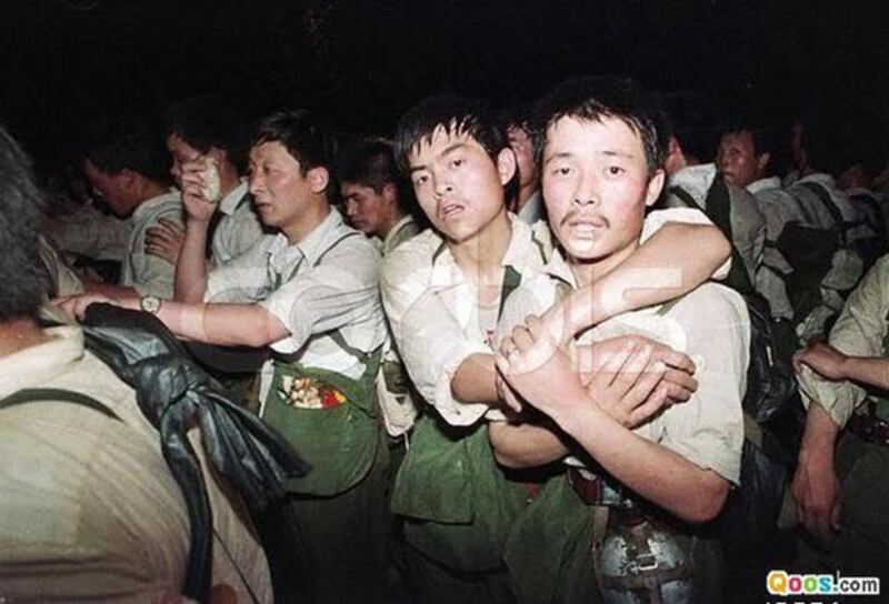 1989年6月2日，穿军便服的军人在北京街头遭到学生和市民围堵。（图源：Qoos.com）