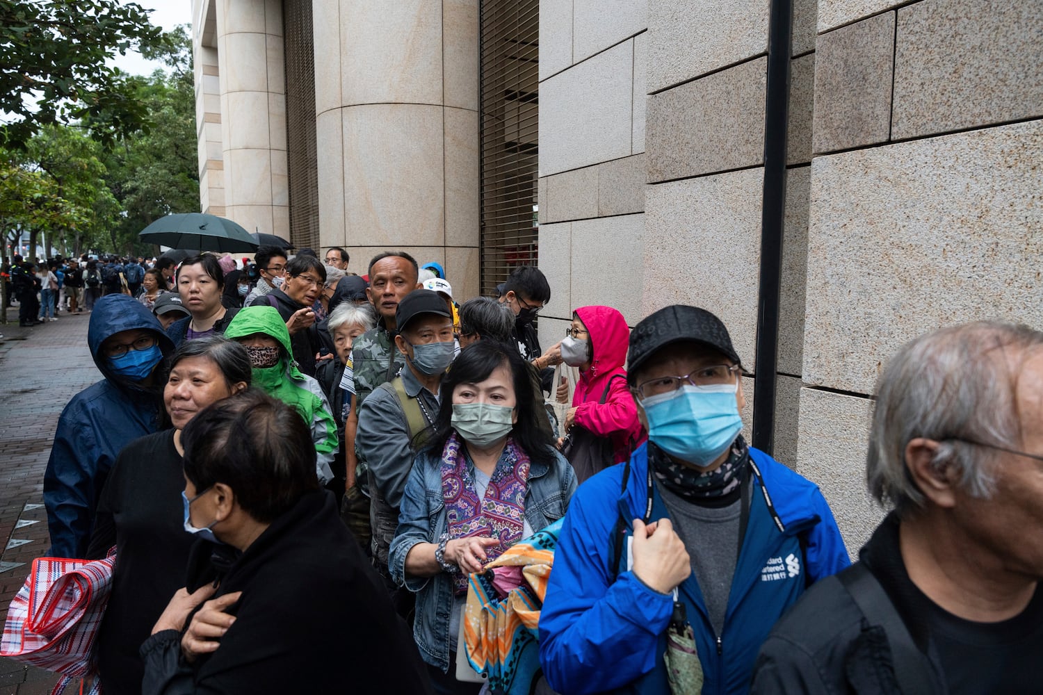 Menschen warten am Dienstag, 19. November 2024, vor dem West Kowloon Magistrates' Court in Hongkong auf die Urteilsverkündung im Fall der nationalen Sicherheit.